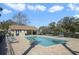 Community pool area featuring lounge chairs, a clubhouse, and lush landscaping at 4300 Hector Ct # 7, Orlando, FL 32822