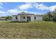 A home's backyard with pristine lawn and a covered patio, perfect for entertaining at 4470 Frances Ave, Sanford, FL 32773