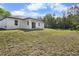 A spacious backyard with a pristine lawn, trees, and a covered patio at 4470 Frances Ave, Sanford, FL 32773