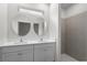 Modern bathroom features double sinks, round mirrors, and a walk-in shower with gray tiling at 4470 Frances Ave, Sanford, FL 32773