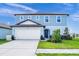 Two-story home with light blue siding, a two-car garage, and well-maintained landscaping at 5433 Keaton Springs Dr, Lakeland, FL 33811