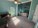 The secondary bedroom offers a floral bed, windows, desk, and great natural light at 619 Blenheim Loop, Winter Springs, FL 32708