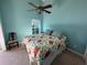 Bedroom featuring light blue walls, floral bedding, ceiling fan and a window at 619 Blenheim Loop, Winter Springs, FL 32708