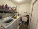 Laundry room features a washer and dryer, utility sink, shelving, and ample storage at 619 Blenheim Loop, Winter Springs, FL 32708