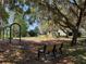Community playground with swings, climbing structures, and seating at 619 Blenheim Loop, Winter Springs, FL 32708