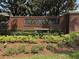 Community entrance sign with brick wall and landscaped flower bed with shrubs and a bench at 619 Blenheim Loop, Winter Springs, FL 32708