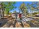 Exterior view of house featuring a red door and concrete patio surrounded by lush greenery and mature trees at 651 W Lake Brantley Rd, Altamonte Springs, FL 32714