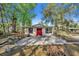 Quaint home with a red door, small patio, and mature trees at 651 W Lake Brantley Rd, Altamonte Springs, FL 32714