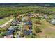 Aerial view of homes with pools alongside the lush green golf course and mature trees at 674 Whisper Woods Dr, Lakeland, FL 33813
