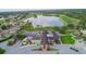 Aerial view of the clubhouse with a beautiful lake, surrounded by lush green landscaping at 674 Whisper Woods Dr, Lakeland, FL 33813