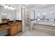 Bright bathroom featuring a shower, soaking tub, and double sinks at 674 Whisper Woods Dr, Lakeland, FL 33813