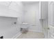 Practical laundry room with sink and shelving for storage at 674 Whisper Woods Dr, Lakeland, FL 33813