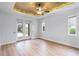 Tranquil primary bedroom with a tray ceiling, and French doors to the backyard at 674 Whisper Woods Dr, Lakeland, FL 33813