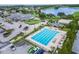 Aerial view of a community pool with plenty of chairs and tables, with a view of a lake and golf course at 674 Whisper Woods Dr, Lakeland, FL 33813