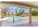 Enclosed pool area featuring a uniquely shaped pool, mature trees, and a screened enclosure at 674 Whisper Woods Dr, Lakeland, FL 33813