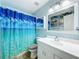 Bathroom with a bright blue beach theme, white vanity, mirror and walk-in shower at 7565 Dockside St, Winter Park, FL 32792