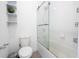 Clean bathroom featuring a white toilet and a shower/tub combo with glass doors and white tile at 7853 Summerlake Groves St, Winter Garden, FL 34787