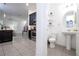 Modern powder room adjacent to kitchen with pedestal sink and tiled floor at 7853 Summerlake Groves St, Winter Garden, FL 34787