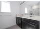 Bathroom with double vanity featuring dark cabinets, quartz countertop, and an oversized frameless mirror at 7853 Summerlake Groves St, Winter Garden, FL 34787