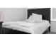 Bright bedroom features a black bed frame with white bedding, with a light grey floor at 7853 Summerlake Groves St, Winter Garden, FL 34787