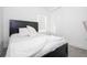 Modern bedroom featuring a black bed frame, plush white bedding, and matching closet doors at 7853 Summerlake Groves St, Winter Garden, FL 34787