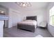 Bright bedroom features a stylish upholstered bed, modern ceiling light, and ample natural light at 7853 Summerlake Groves St, Winter Garden, FL 34787