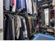 Organized walk-in closet features custom shelving, drawers, clothing racks, mirror, and floor lighting at 7853 Summerlake Groves St, Winter Garden, FL 34787