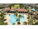 Community pool area surrounded by palm trees, lounge chairs, and a clubhouse at 7853 Summerlake Groves St, Winter Garden, FL 34787