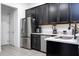 Modern kitchen boasts stainless steel appliances and elegant black cabinetry at 7853 Summerlake Groves St, Winter Garden, FL 34787