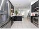 Open kitchen concept with stainless steel appliances, black cabinetry, and tiled floors at 7853 Summerlake Groves St, Winter Garden, FL 34787