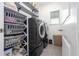 Well-organized laundry room with modern washer and dryer, shelves, and storage baskets at 7853 Summerlake Groves St, Winter Garden, FL 34787