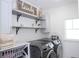 Bright laundry room featuring modern appliances, ample storage shelves, and stylish decor at 7853 Summerlake Groves St, Winter Garden, FL 34787
