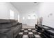 Bright living room features gray reclining sofa, patterned rug, white walls and light grey flooring at 7853 Summerlake Groves St, Winter Garden, FL 34787