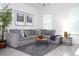 Bright living room boasts neutral tones, a large sectional sofa, and stylish decor for comfortable and modern living at 7853 Summerlake Groves St, Winter Garden, FL 34787
