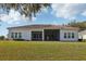 Backyard view of home with a screened lanai, a stucco exterior, and a manicured lawn at 8064 Peaceful Cir, Sanford, FL 32771