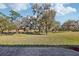 Expansive backyard featuring lush green grass and mature trees and a brick paver patio at 8064 Peaceful Cir, Sanford, FL 32771
