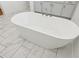 Bright bathroom featuring a standalone tub and white marble tile floors at 8064 Peaceful Cir, Sanford, FL 32771