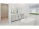 Bright bathroom featuring a standalone tub and separate glass-enclosed shower at 8064 Peaceful Cir, Sanford, FL 32771