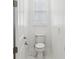 Bright half bathroom featuring a toilet, white vanity, tile floors and a window with blinds at 8064 Peaceful Cir, Sanford, FL 32771