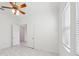 Bright bedroom with white walls, a ceiling fan, two doors, one window, and marble flooring at 8064 Peaceful Cir, Sanford, FL 32771