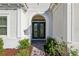 Elegant front entryway featuring double doors, an arched entrance, and decorative shrubs at 8064 Peaceful Cir, Sanford, FL 32771