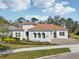 Elegant home with a manicured lawn, paver driveway, lush landscaping, and an arched entryway at 8064 Peaceful Cir, Sanford, FL 32771