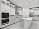 Spacious kitchen featuring white cabinetry, stainless steel appliances, a center island, and marble flooring at 8064 Peaceful Cir, Sanford, FL 32771
