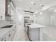 Bright kitchen features white cabinets, stainless steel appliances, and a large center island with pendant lighting at 8064 Peaceful Cir, Sanford, FL 32771
