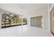 Spacious lanai with white floors, expansive screen windows showcasing beautiful outdoor views, and a ceiling fan at 8064 Peaceful Cir, Sanford, FL 32771