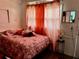 Bedroom with pink bedding, coral curtains, wood floors, and natural light at 914 2Nd St, Orlando, FL 32824