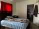 Bedroom with a blue and white plaid bedspread, dark wood furniture and a red curtain at 914 2Nd St, Orlando, FL 32824