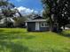 Side view of a cozy single-Gathering home featuring a white back door and vibrant green lawn at 914 2Nd St, Orlando, FL 32824