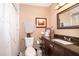 Cozy bathroom featuring shower, vanity with dark cabinets and granite top, decorated with modern accents at 1012 E De Carlo Dr, Deltona, FL 32725