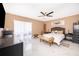 Spacious main bedroom featuring ceiling fan, neutral walls, white marbled-tile floors, and backyard access at 1012 E De Carlo Dr, Deltona, FL 32725